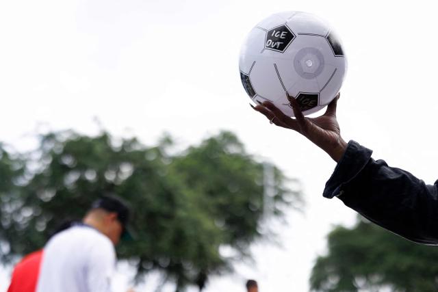 An Organized Power In Numbers (OPIN) staff member distributes soccer balls with “ICE OUT” messages outside of Houston Stadium in Houston, Texas, on June 14, 2026 before the 2026 World Cup Group E football match between Germany and Curacao. (Photo by Mark Felix / AFP)