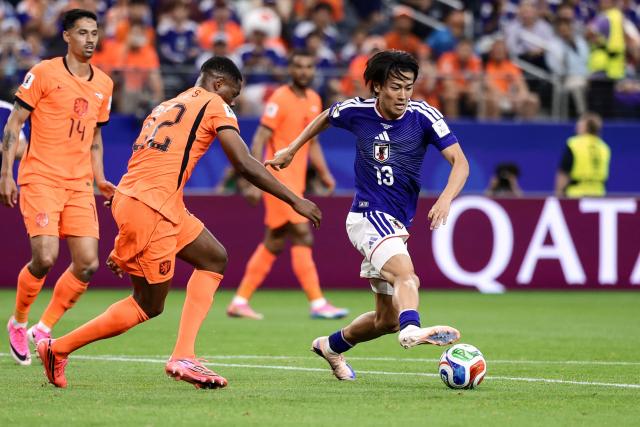 Japan's midfielder #13 Keito Nakamura (R) fights for the ball with Netherlands' defender #22 Denzel Dumfries  during the 2026 World Cup Group F football match between the Netherlands and Japan at the Dallas Stadium in Arlington on June 14, 2026.  (Photo by Aric Becker / AFP)