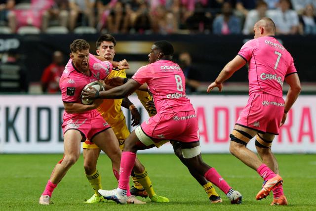 Stade Français' New Zealand scrum-half Tawera Kerr-Barlow (L) is tackled by La Rochelle's French scrum-half Nolann Le Garrec (2nd L) during the French Top14 rugby union play-off match between Stade Francais Paris and Stade Rochelais (La Rochelle) at the Jean-Bouin Stadium in Paris on June 14, 2026. (Photo by GEOFFROY VAN DER HASSELT / AFP)