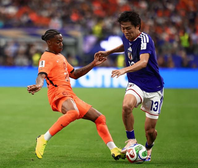 Japan's midfielder #13 Keito Nakamura (R) fights for the ball with Netherlands' forward #24 Crysencio Summerville  during the 2026 World Cup Group F football match between the Netherlands and Japan at the Dallas Stadium in Arlington on June 14, 2026.  (Photo by Aric Becker / AFP)