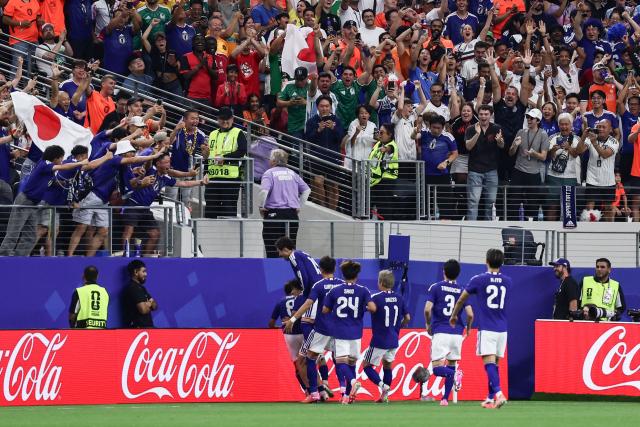 Japan's players celebrate with supporters after scoring their first goal during the 2026 World Cup Group F football match between the Netherlands and Japan at the Dallas Stadium in Arlington on June 14, 2026.  (Photo by Aric Becker / AFP)