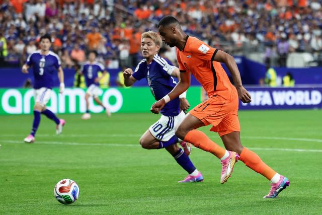 Netherlands' forward #11 Cody Gakpo  (R) fights for the ball with Japan's midfielder #10 Ritsu Doan  during the 2026 World Cup Group F football match between the Netherlands and Japan at the Dallas Stadium in Arlington on June 14, 2026.  (Photo by Aric Becker / AFP)