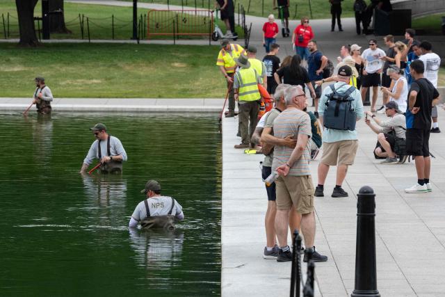 National Park Service workers push algae towards an aeration area in the center of the Lincoln Memorial Reflecting Pool following the completion of recent renovations in Washington, DC, on June 14, 2026. The reflecting pool project, undertaken as part of President Donald Trump’s preparations for the nation’s 250th anniversary, began in April and was completed last week. (Photo by Ken CEDENO / AFP)