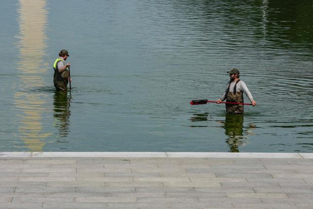 National Park Service workers push algae towards an aeration area in the center of the Lincoln Memorial Reflecting Pool following the completion of recent renovations in Washington, DC, on June 14, 2026. The reflecting pool project, undertaken as part of President Donald Trump’s preparations for the nation’s 250th anniversary, began in April and was completed last week. (Photo by Ken CEDENO / AFP)