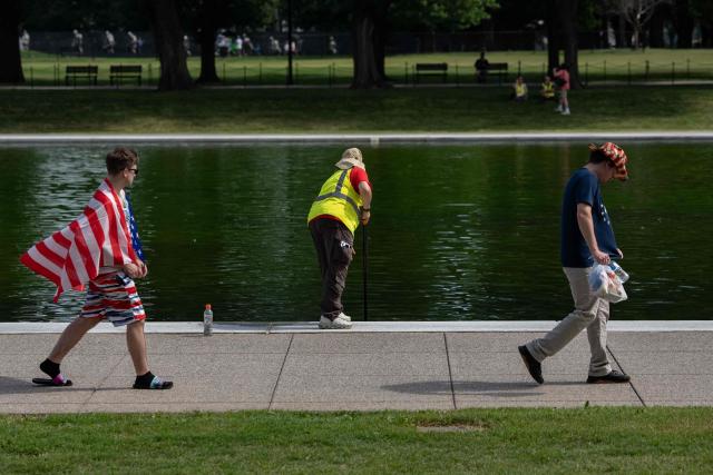 National Park Service workers push algae towards an aeration area in the center of the Lincoln Memorial Reflecting Pool following the completion of recent renovations in Washington, DC, on June 14, 2026. The reflecting pool project, undertaken as part of President Donald Trump’s preparations for the nation’s 250th anniversary, began in April and was completed last week. (Photo by Ken CEDENO / AFP)