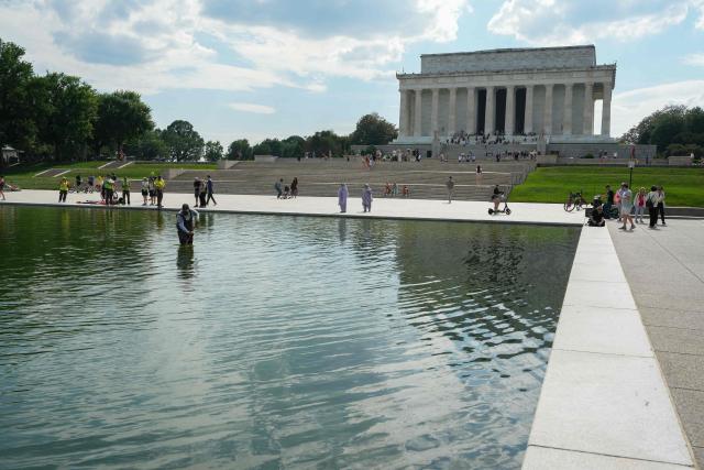 National Park Service workers push algae towards an aeration area in the center of the Lincoln Memorial Reflecting Pool following the completion of recent renovations in Washington, DC, on June 14, 2026. The reflecting pool project, undertaken as part of President Donald Trump’s preparations for the nation’s 250th anniversary, began in April and was completed last week. (Photo by Ken CEDENO / AFP)