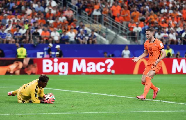 Netherlands' midfielder #20 Teun Koopmeiners (R) fights for the ball with Japan's goalkeeper #01 Zion Suzuki during the 2026 World Cup Group F football match between the Netherlands and Japan at the Dallas Stadium in Arlington on June 14, 2026.  (Photo by Aric Becker / AFP)