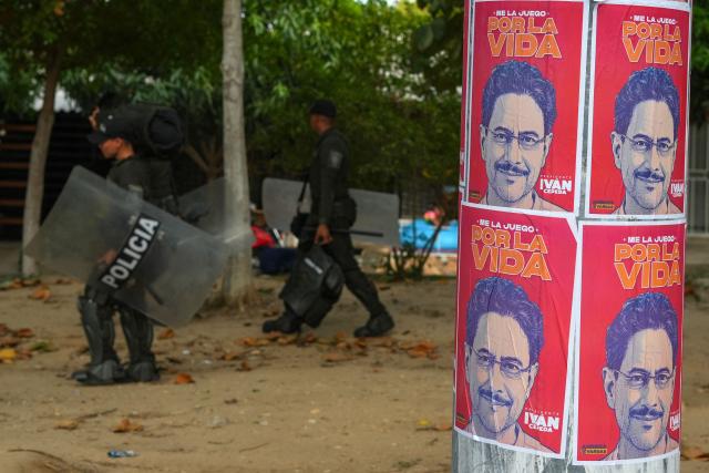 Members of the national police walk past banners of Colombia's presidential candidate for the Pacto Historico party Ivan Cepeda, before the closing rally of his campaign in Barranquilla, Colombia, on June 14, 2026. Colombia will hold the runoff presidential election on June 21. (Photo by Vanexa Romero / AFP)