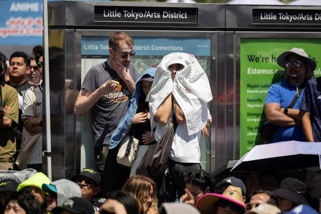 A supporter of Japan wraps himself under his shirt to shield himself from the sun and heat during the second half of the match of the 2026 World Cup football tournament between Japan and the Netherlands, at a watch party in the Little Tokyo neighborhood of Los Angeles, California, on June 14, 2026. (Photo by ETIENNE LAURENT / AFP)