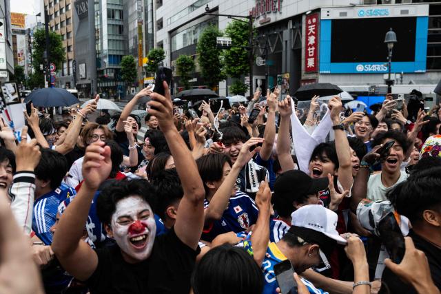 Fans celebrate early in the morning at Shibuya Crossing in Tokyo on June 15, 2026, after Japan’s 2–2 draw with the Netherlands in the 2026 World Cup. (Photo by Andrew CABALLERO-REYNOLDS / AFP)