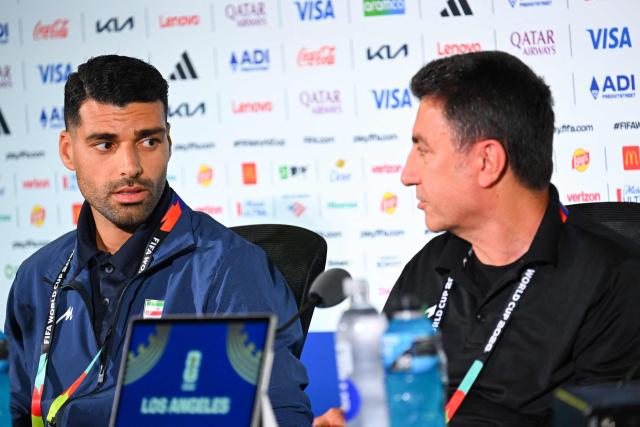 Iran's head coach Amir Ghalenoei (R) gives a press conference next to Iran’s forward #09 Mehdi Taremi at Los Angeles Stadium in Inglewood on June 14, 2026, on the eve of the 2026 World Cup football match between Iran and New Zealand. (Photo by Patrick T. FALLON / AFP)