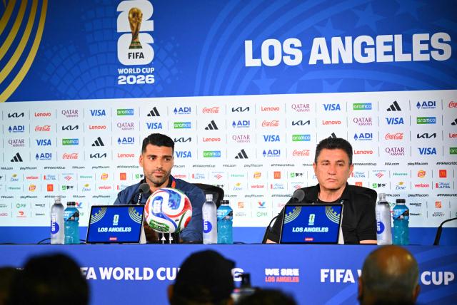 Iran's head coach Amir Ghalenoei (R) gives a press conference next to Iran’s forward #09 Mehdi Taremi at Los Angeles Stadium in Inglewood on June 14, 2026, on the eve of the 2026 World Cup football match between Iran and New Zealand. (Photo by Patrick T. FALLON / AFP)