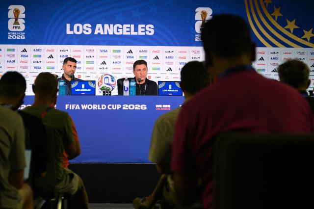 Iran's head coach Amir Ghalenoei (R) gives a press conference next to Iran’s forward #09 Mehdi Taremi at Los Angeles Stadium in Inglewood on June 14, 2026, on the eve of the 2026 World Cup football match between Iran and New Zealand. (Photo by Patrick T. FALLON / AFP)