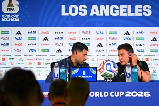 Iran's head coach Amir Ghalenoei (R) gives a press conference next to Iran’s forward #09 Mehdi Taremi at Los Angeles Stadium in Inglewood on June 14, 2026, on the eve of the 2026 World Cup football match between Iran and New Zealand. (Photo by Patrick T. FALLON / AFP)