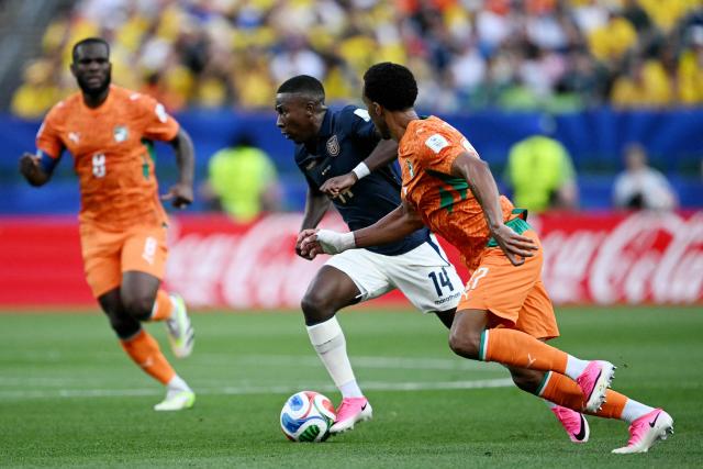 Ecuador's midfielder #14 Alan Minda runs with the ball past Ivory Coast's defender #17 Guela Doue during the 2026 World Cup Group E football match between Ivory Coast and Ecuador at the Philadelphia Stadium in Philadelphia on June 14, 2026.  (Photo by MAURO PIMENTEL / AFP)