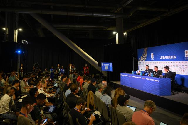 Iran's head coach Amir Ghalenoei (C) gives a press conference next to Iran’s forward #09 Mehdi Taremi (L) at Los Angeles Stadium in Inglewood on June 14, 2026, on the eve of the 2026 World Cup football match between Iran and New Zealand. (Photo by Patrick T. FALLON / AFP)