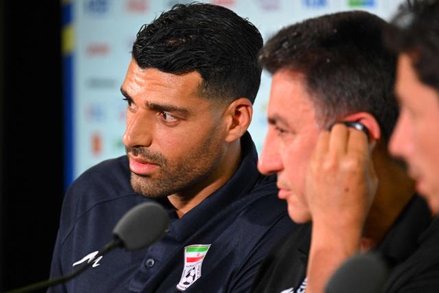 Iran's head coach Amir Ghalenoei (R) gives a press conference next to Iran’s forward #09 Mehdi Taremi at Los Angeles Stadium in Inglewood on June 14, 2026, on the eve of the 2026 World Cup football match between Iran and New Zealand. (Photo by Patrick T. FALLON / AFP)