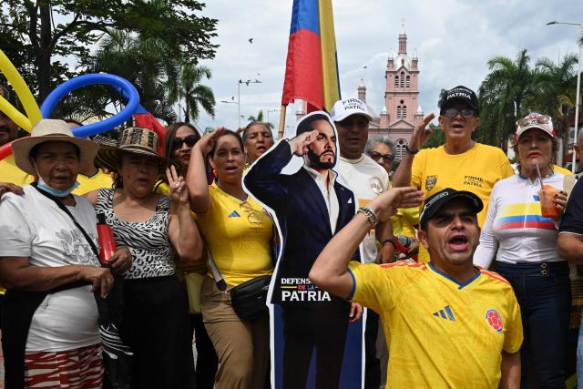 Supporters of Colombia's presidential candidate Abelardo de la Espriella, of the Salvadores de la Patria movement, salute next to a figure of him during his closing campaign rally in Buga, Valle del Cauca department, Colombia on June 14, 2026. Colombia will hold the runoff presidential election on June 21. (Photo by Joaquin SARMIENTO / AFP)