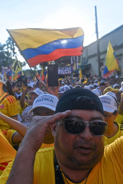 Supporters of Colombia's presidential candidate Abelardo de la Espriella, of the Salvadores de la Patria movement, salute during his closing campaign rally in Buga, Valle del Cauca department, Colombia on June 14, 2026. Colombia will hold the runoff presidential election on June 21. (Photo by Joaquin SARMIENTO / AFP)
