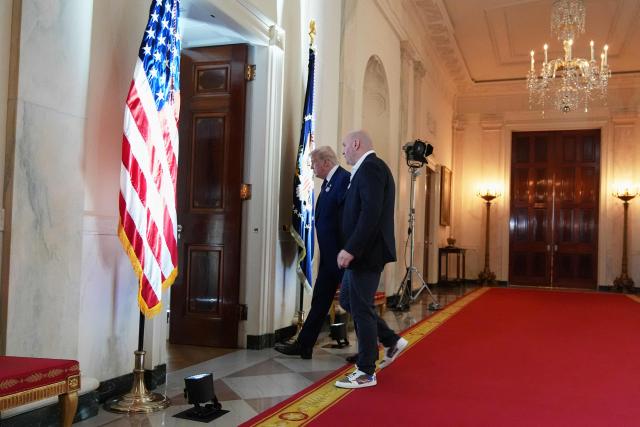 US President Donald Trump walks with UFC president and CEO Dana White through the Cross Hall of the White House before attending the UFC Freedom 250 fights on the South Lawn of the White House, in Washington, DC, on June 14, 2026. (Photo by Jacquelyn Martin / POOL / AFP)