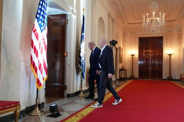 US President Donald Trump walks with UFC president and CEO Dana White through the Cross Hall of the White House before attending the UFC Freedom 250 fights on the South Lawn of the White House, in Washington, DC, on June 14, 2026. (Photo by Jacquelyn Martin / POOL / AFP)
