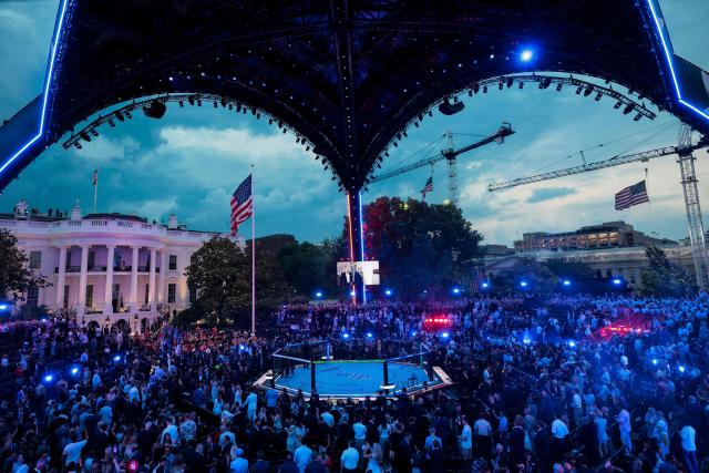 A screen shows US President Donald Trump walking with UFC President and CEO Dana White, as people attend UFC Freedom 250 on the South Lawn of the White House in Washington, DC, on June 14, 2026. (Photo by Evan Vucci / POOL / AFP)