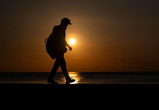 A man walks along the Malecon in Havana at sunset on June 14, 2026. (Photo by YAMIL LAGE / AFP)