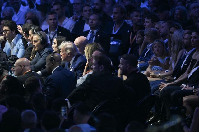 US President Donald Trump and First Lady Melania Trump, along with Ultimate Fighting Championship President and CEO Dana White, joined by Eric Trump and Donald Trump Jr. seated behind them, watch mixed martial artists Brazil’s Diego Lopes and US fighter Steve Garcia compete in their featherweight bout during the “UFC Freedom 250” mixed martial arts event on the South Lawn of the White House in Washington, DC, on June 14, 2026. (Photo by Brendan SMIALOWSKI / AFP)