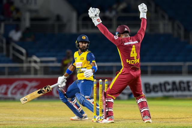 Kamil Mishara (L) of Sri Lanka is dismissed by Roston Chase of West Indies during the third Twenty20 (T20) international cricket match between West Indies and Sri Lanka at Sabina Park in Kingston, Jamaica, on June 14, 2026. (Photo by Randy Brooks / AFP)