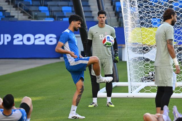 Iran's forward #11 Ali Alipour and goalkeeper #12 Payam Niazmand take part in a training session at Carson Sports Park in Carson, California on June 14, 2026, on the eve of the 2026 World Cup football match between Iran and New Zealand.  (Photo by Patrick T. Fallon / AFP)