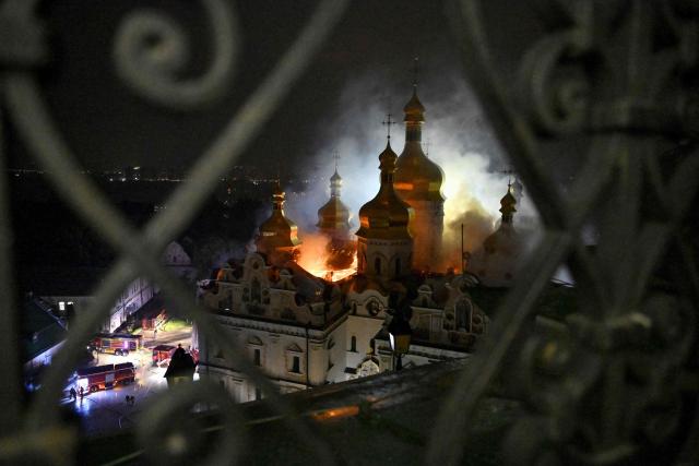Smoke and fire rises from the Dormition Cathedral in the Orthodox complex of the Kyiv Pechersk Lavra following a Russian missile strike on the Ukrainian capital Kyiv on June 15, 2026, amid the Russian invasion in Ukraine. A major missile attack struck Kyiv early on June 15, an AFP reporter witnessed, with projectiles intercepted in the sky and glowing debris falling onto the city. Ukrainian officials including the city's mayor Vitali Klitschko reported on Telegram that strikes hit various districts. (Photo by Genya Savilov / AFP)