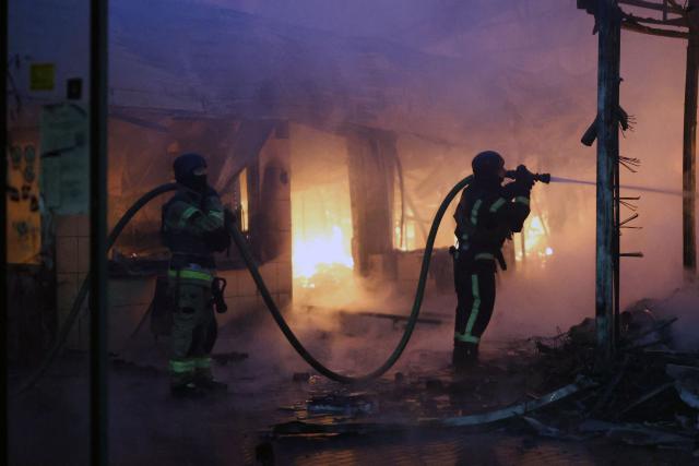 Firefighters put out a blaze at a market during the Russian missile strike on the Ukrainian capital of Kyiv on June 15, 2026, amid the Russian invasion in Ukraine. A major missile attack struck Kyiv early on June 15, an AFP reporter witnessed, with projectiles intercepted in the sky and glowing debris falling onto the city. Ukrainian officials including the city's mayor Vitali Klitschko reported on Telegram that strikes hit various districts. (Photo by Serhii Okunev / AFP)