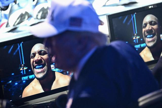 US President Donald Trump watches as France's Ciryl Gane is displayed on a monitor in front of him during the "UFC Freedom 250" mixed martial arts event on the South Lawn of the White House in Washington, DC, June 14, 2026. (Photo by Kent NISHIMURA / AFP)