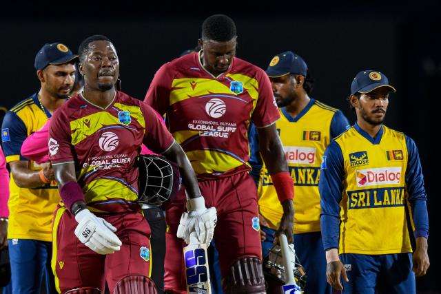 Sherfane Rutherford (L) and Jason Holder (R) of West Indies walk off the field after winning the third Twenty20 (T20) international cricket match between West Indies and Sri Lanka at Sabina Park in Kingston, Jamaica, on June 14, 2026.  (Photo by Randy Brooks / AFP)