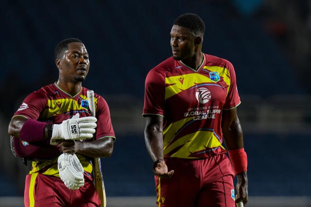 Sherfane Rutherford (L) and Jason Holder (R) of West Indies walk off the field after winning the third Twenty20 (T20) international cricket match between West Indies and Sri Lanka at Sabina Park in Kingston, Jamaica, on June 14, 2026.  (Photo by Randy Brooks / AFP)