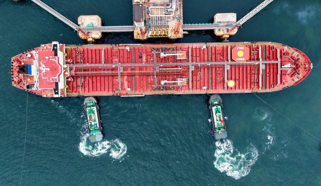 An oil tanker is moved to its berth at the crude oil terminal at the port in Qingdao, in China’s eastern Shandong province on June 14, 2026. (Photo by CN-STR / AFP) / China OUT
