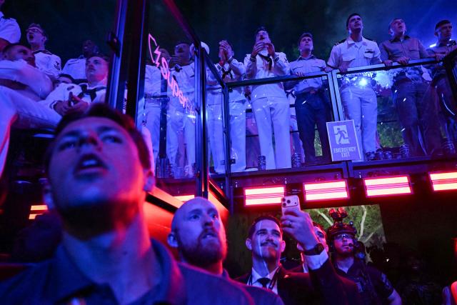 Members of the US military (top), event staff and security watch during the "UFC Freedom 250" mixed martial arts event on the South Lawn of the White House in Washington, DC, in the early morning hours of June 15, 2026. (Photo by Kent NISHIMURA / AFP)
