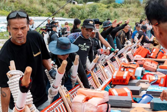 The Tao (Yami) indigenous rowers launch a traditional wooden canoe called Ovayan (Golden Friendship) for its voyage to Philippines' Batanes Islands, along the coastline at Orchid island (or Lanyu island), southeastern Taiwan on June 15, 2026. (Photo by CHENG Yu-chen / AFP)