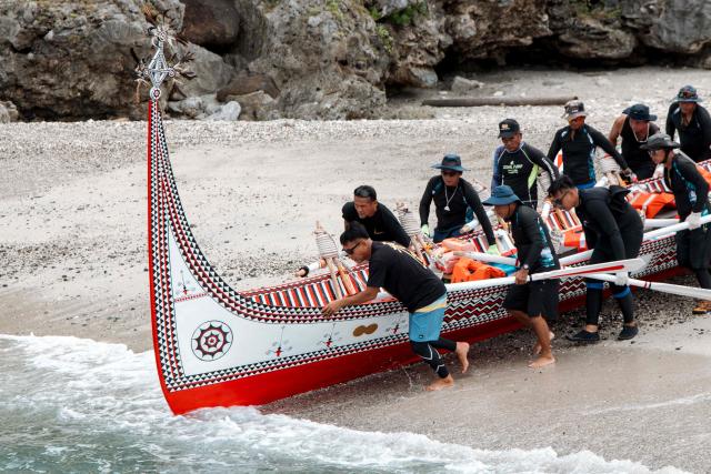 The Tao (Yami) indigenous rowers launch a traditional wooden canoe called Ovayan (Golden Friendship) for its voyage to Philippines' Batanes Islands, along the coastline at Orchid island (or Lanyu island), southeastern Taiwan on June 15, 2026. (Photo by CHENG Yu-chen / AFP)