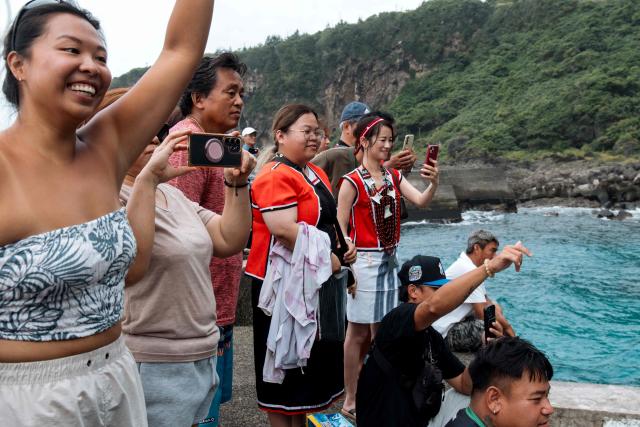 Residents wave to the crew aboard a traditional wooden canoe called Ovayan (Golden Friendship) before their voyage to Philippines' Batanes Islands, off Orchid island (or Lanyu island) in southeastern Taiwan on June 15, 2026. (Photo by CHENG Yu-chen / AFP)