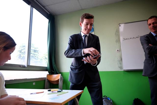 France's Education Minister Edouard Geffray distributes exam papers as a 4 hours philosophy dissertation kicks off the French general baccalaureat exam for getting into university, at Louis Armand high school in Nogent-sur-Marne on June 15, 2026. More than 700,000 candidates across France take the 2026 session of the Baccalaureat or "bac", the secondary school diploma required for access to higher education, with written exams running from June 15 to 18 and oral examinations through early July. (Photo by SIMON WOHLFAHRT / AFP)