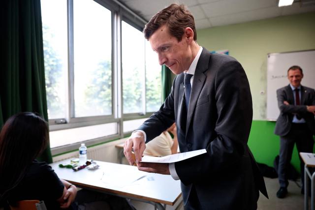 France's Education Minister Edouard Geffray distributes exam papers as a 4 hours philosophy dissertation kicks off the French general baccalaureat exam for getting into university, at Louis Armand high school in Nogent-sur-Marne on June 15, 2026. More than 700,000 candidates across France take the 2026 session of the Baccalaureat or "bac", the secondary school diploma required for access to higher education, with written exams running from June 15 to 18 and oral examinations through early July. (Photo by SIMON WOHLFAHRT / AFP)