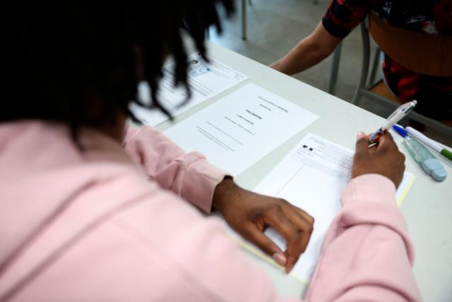 A student fills the exam paper as a 4 hours philosophy dissertation kicks off the French general baccalaureat exam for getting into university, at Louis Armand high school in Nogent-sur-Marne on June 15, 2026. More than 700,000 candidates across France take the 2026 session of the Baccalaureat or "bac", the secondary school diploma required for access to higher education, with written exams running from June 15 to 18 and oral examinations through early July. (Photo by SIMON WOHLFAHRT / AFP)