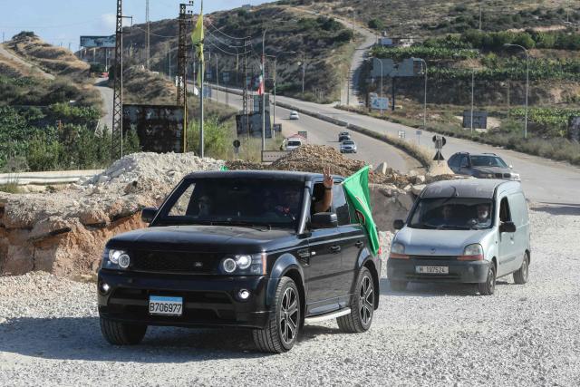 A man flashes the V-sign as displaced residents cross the Bourj Rahal bridge on their way to their villages in southern Lebanon on June 15, 2026. The United States and Iran said they reached a deal to end the Middle East war on all fronts including Lebanon, and reopen the vital Strait of Hormuz, but offered little indication on the thorny question of Tehran's nuclear programme. Washington and Islamabad said the agreement was to be signed on June 19 in Switzerland, signalling what would be a major breakthrough to ending months of war that have taken thousands of lives and roiled energy markets. (Photo by Kawnat HAJU / AFP) / 