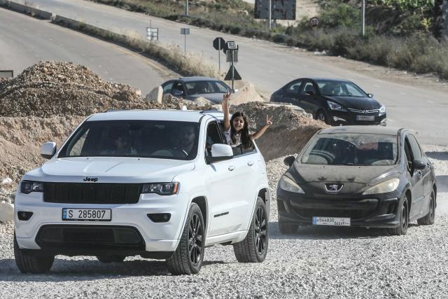 A girl flashes the V-sign from a vehicle as displaced residents cross the Bourj Rahal bridge on their way to their village in southern Lebanon on June 15, 2026. The United States and Iran said they reached a deal to end the Middle East war on all fronts including Lebanon, and reopen the vital Strait of Hormuz, but offered little indication on the thorny question of Tehran's nuclear programme. Washington and Islamabad said the agreement was to be signed on June 19 in Switzerland, signalling what would be a major breakthrough to ending months of war that have taken thousands of lives and roiled energy markets. (Photo by Kawnat HAJU / AFP) / 