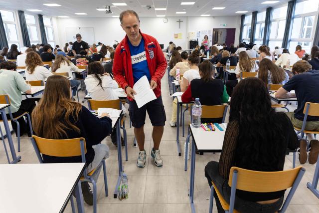 A supervisor distributes exam papers as a 4 hours philosophy dissertation kicks off the French general baccalaureat exam for getting into university, in Quimper on June 15, 2026. More than 700,000 candidates across France take the 2026 session of the Baccalaureat or "bac", the secondary school diploma required for access to higher education, with written exams running from June 15 to 18 and oral examinations through early July. (Photo by Fred TANNEAU / AFP)