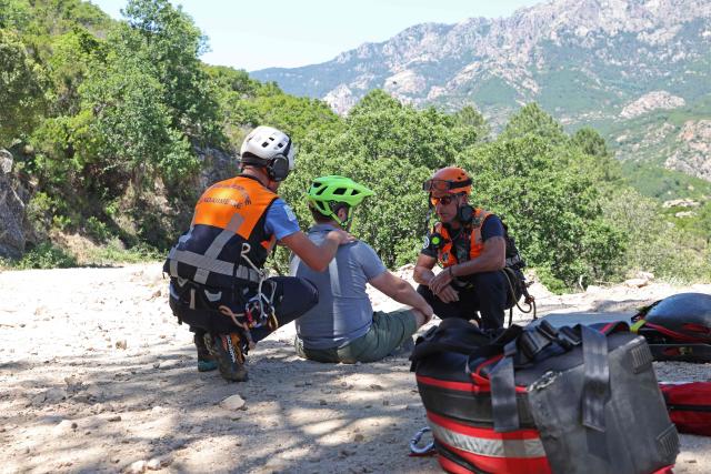 Members of Ajaccio's High Mountain Gendarmerie Platoon (PGHM, Peleton de Gendarmerie de Haute Montagne), an elite unit of the French Gendarmerie specializing in mountain rescue and law enforcement in high-altitude and alpine environments, prepare to evacuate an injuried tourist from a fall in bicycle inside the Bavella mountain inside the gendarme helicoptere in Zonza on the French Mediterranean island of Corsica on June 12, 2026. (Photo by Pascal POCHARD-CASABIANCA / AFP)