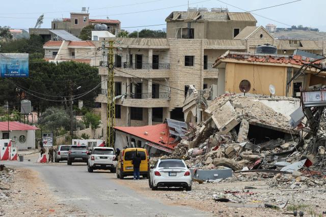 Vehicles line up along destroyed buildings as Lebanese soldiers set up a checkpoint in the southern village of Kafra, closing the road leading to the nearby village of Haris, where the Israeli military remains present, on June 15, 2026. Israel's defence minister said on June 15, that Israeli forces would remain in Lebanon, Syria and Gaza indefinitely, hours after the United States and Iran agreed to end the Middle East war, including in Lebanon. (Photo by Kawnat HAJU / AFP) / 