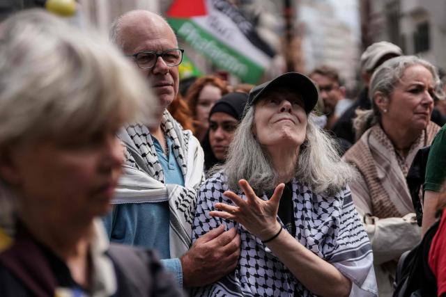 People react as they listen to the court proceedings outside the Royal Courts Of Justice in central London on June 15, 2026, as the High Court rules on a legal standoff between the government and activist group Palestine Action. London's Court of Appeal on June 15 upheld a government ban on the Palestine Action activist group imposed under terrorism legislation, following a legal challenge. (Photo by CARLOS JASSO / AFP)