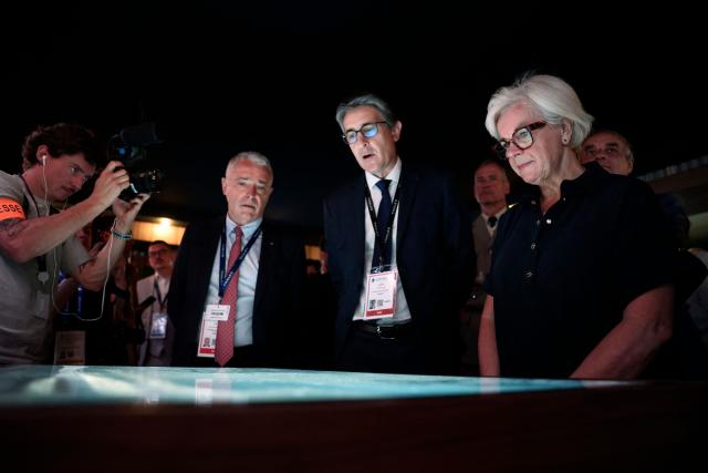 France's Defence Minister Catherine Vautrin (R) listens to Chief Executive Officer of French aerospace and defence group Thales, Patrice Caine (C) at the Thales stand at the Eurosatory land and airland defence and security trade fair, at the Paris-Nord Villepinte Exhibition Centre in Villepinte, north of Paris, on June 15, 2026. (Photo by Guillaume BAPTISTE / AFP)